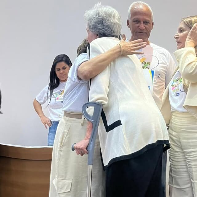 Voluntários se abraçam antes da ação